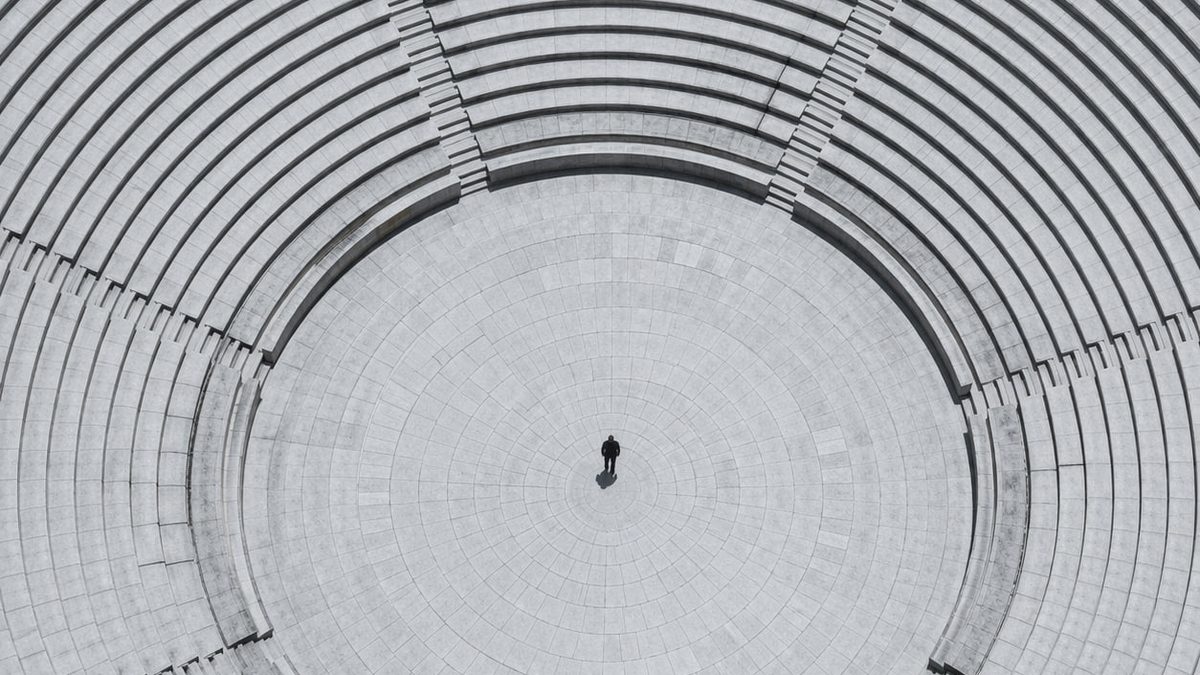 Individuum im System — Kreisförmige Arena Vogelperspektive — Unternehmensstrafrecht Compliance