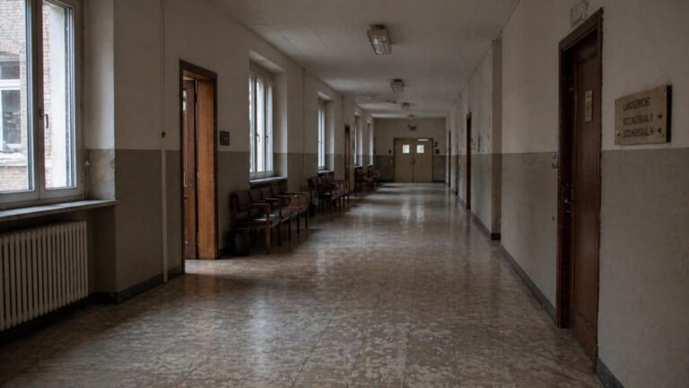 Leerer Flur eines deutschen Landgerichts mit Hinweisschildern zu den Sitzungssälen — Strafverfahren wegen Insolvenzverschleppung nach § 15a InsO