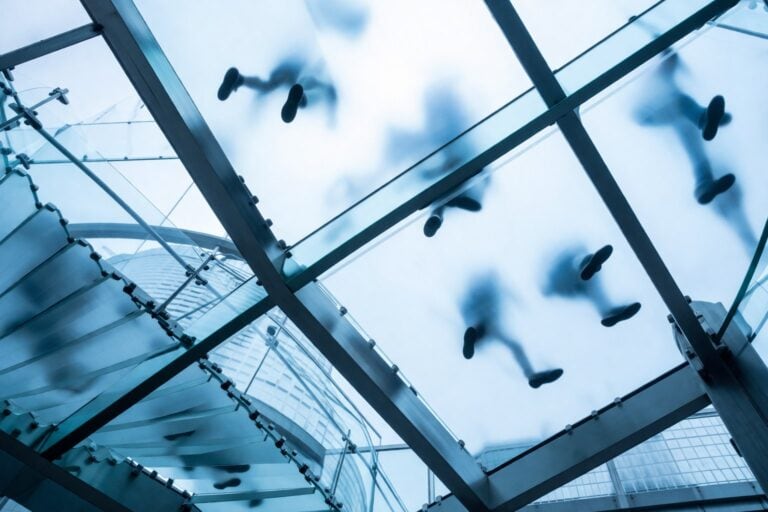 Whistleblowing und Anonymität — verschwommene Personen auf Glastreppe