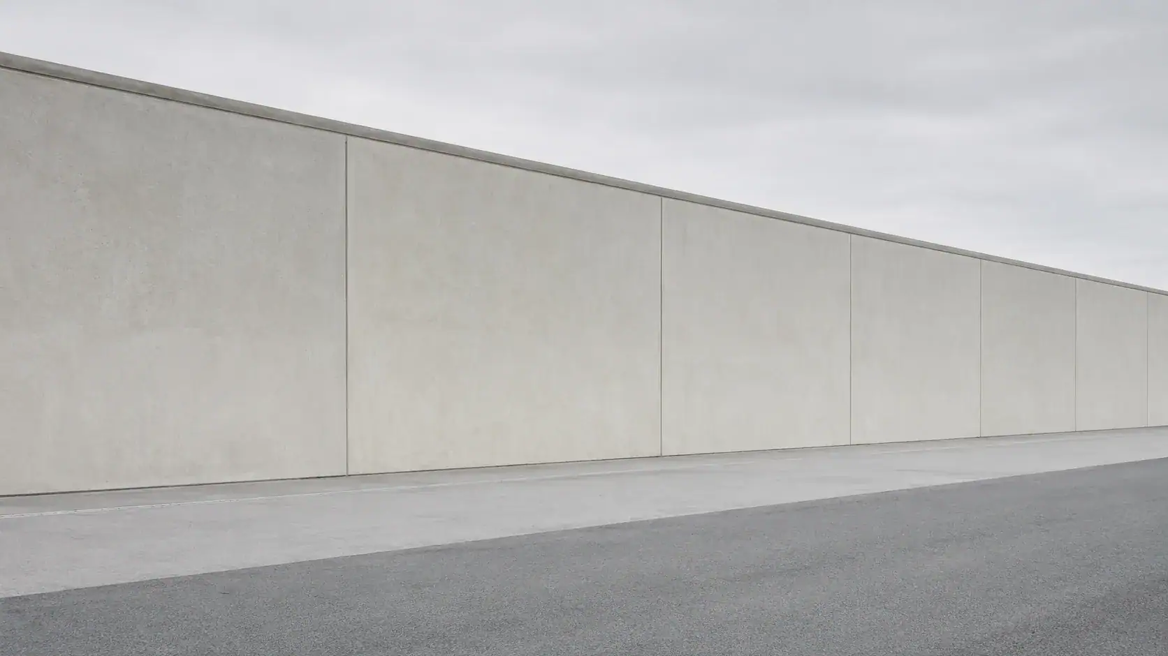 Betonsichtmauer als Perimeterschutz — Symbol für Geheim- und Sabotageschutz im Unternehmen