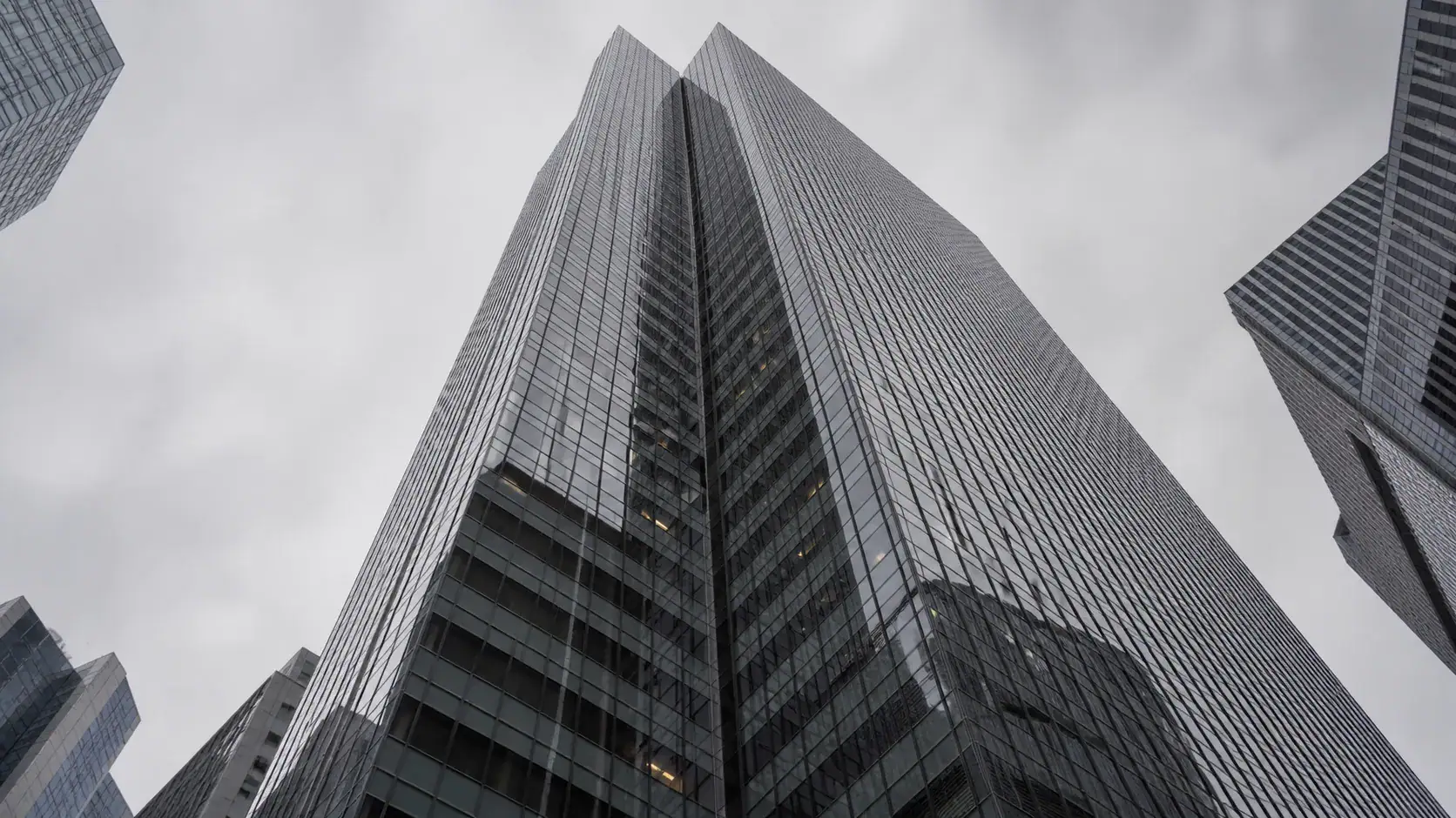 Hochhaus von unten unter bedecktem Himmel — Kapitalmarktstrafrecht, Insiderhandel und Marktmanipulation.