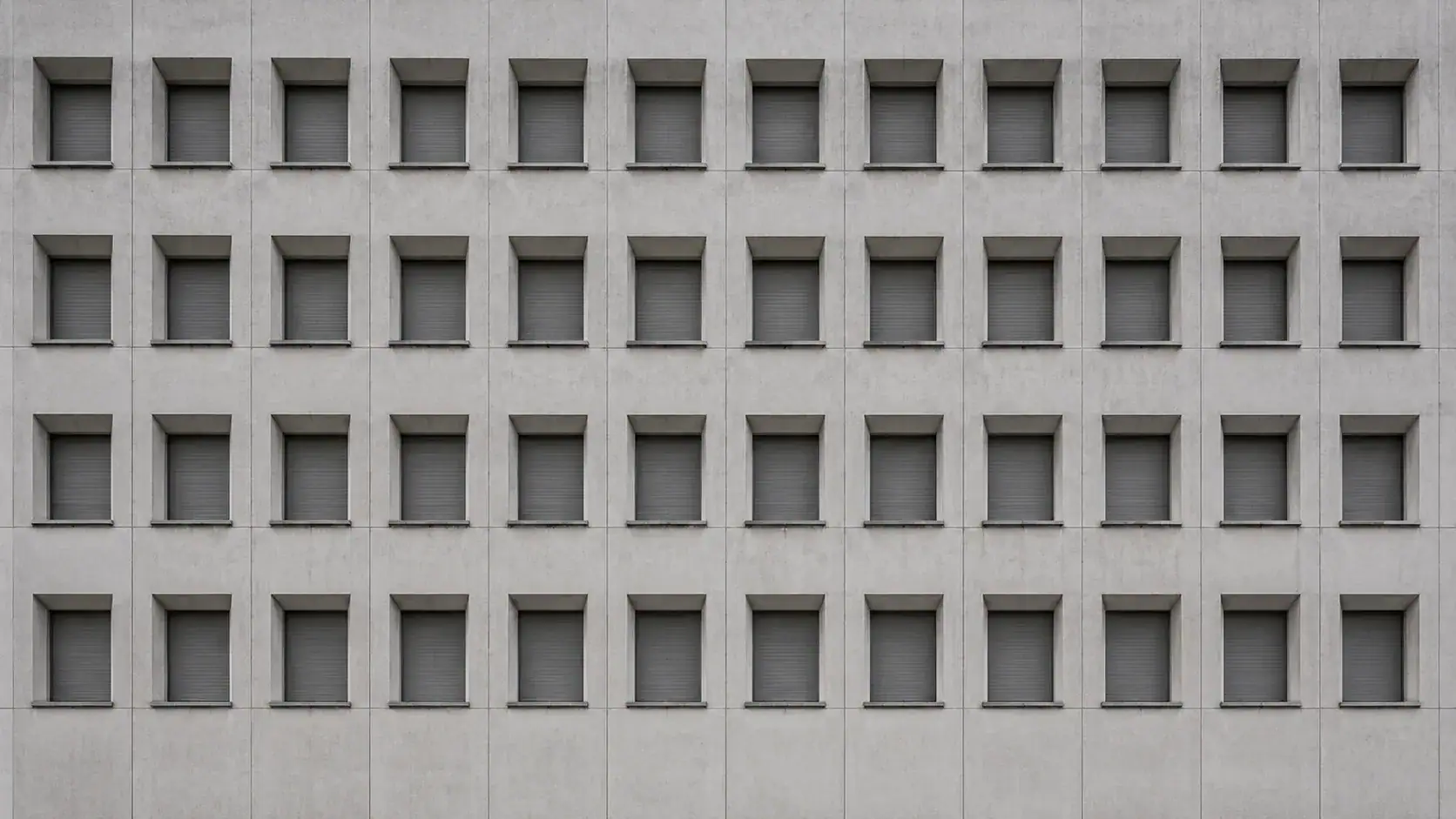 Strenges Fensterraster einer Behördenfassade — Steuerhinterziehung und Selbstanzeige nach § 370 AO.