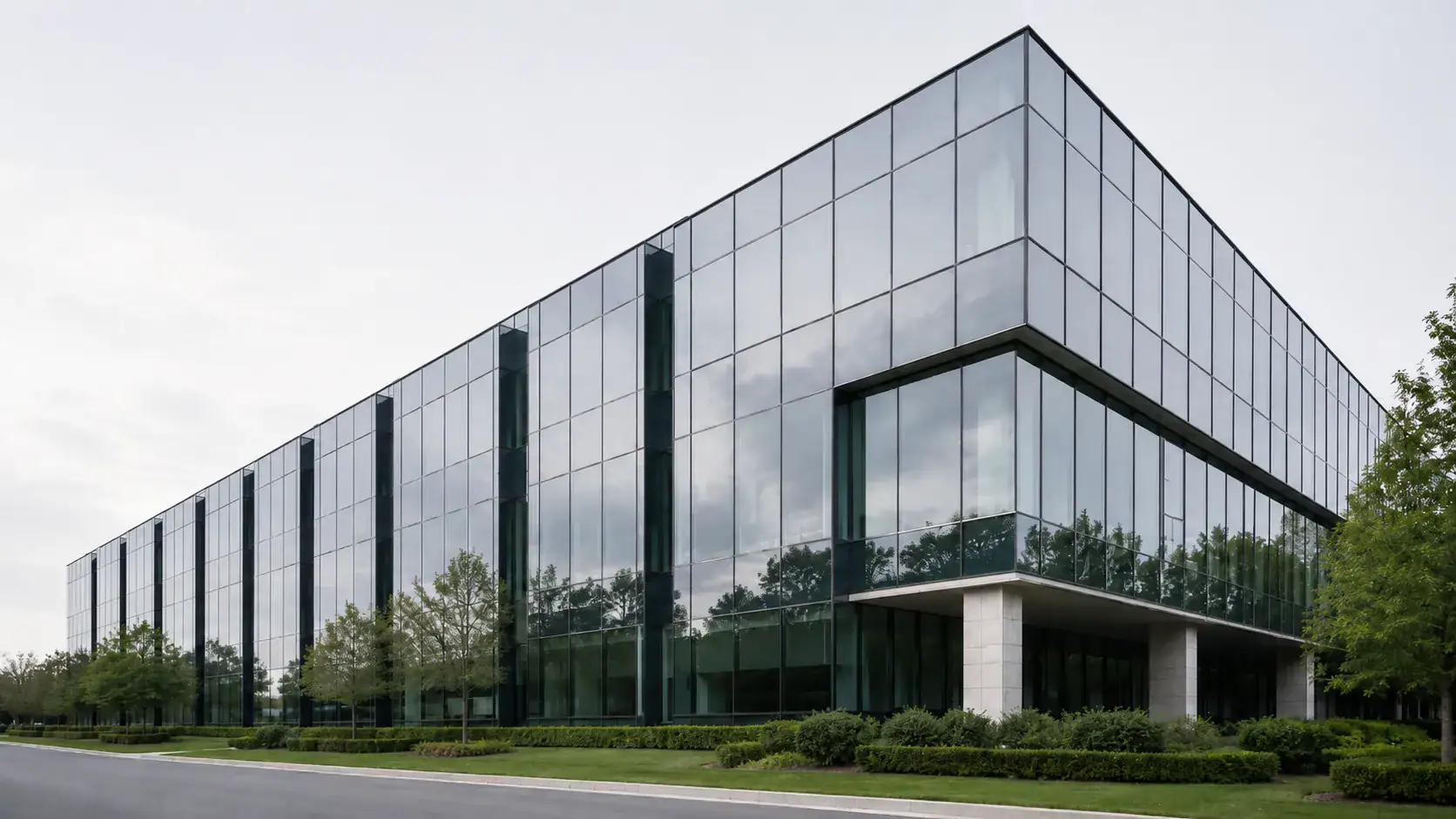 Glas-Bürogebäude unter bedecktem Himmel — Unternehmensstrafrecht und strafrechtliche Unternehmensverantwortung.