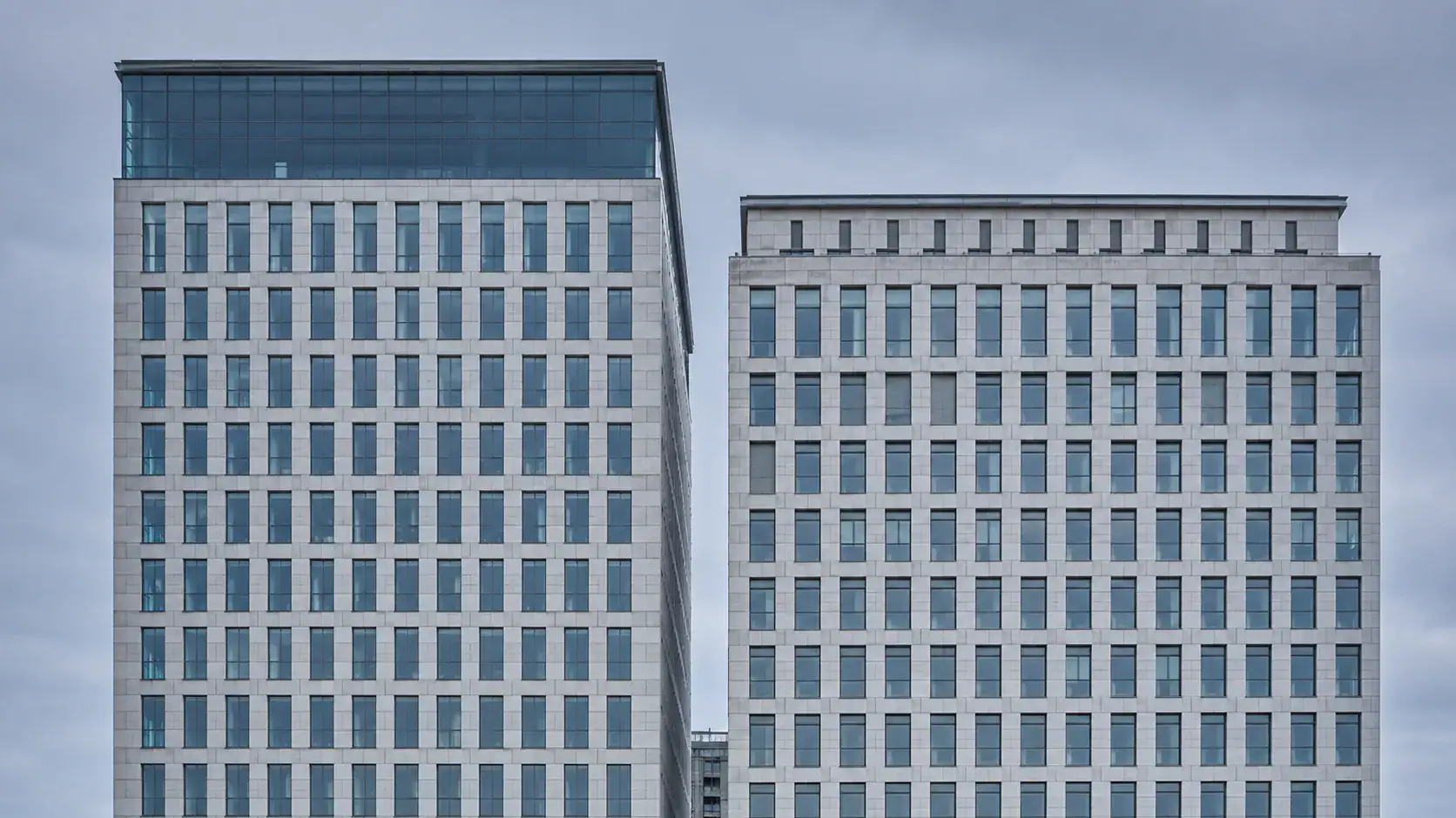 Zwei Bürogebäude nebeneinander — Symbol für staatlich gelenkte Wirtschaftsspionage und Konkurrenzausspähung