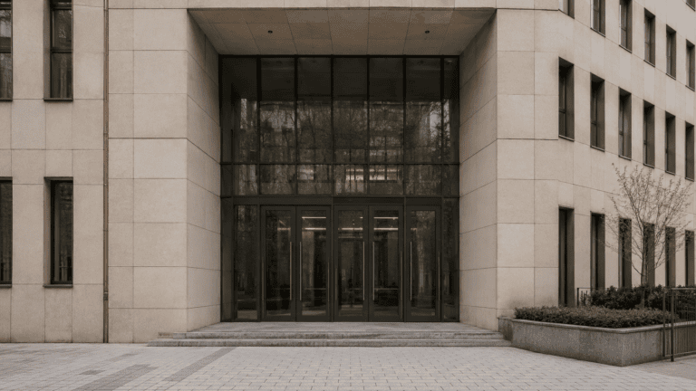 Eingang eines repräsentativen Gerichts- oder Kanzleigebäudes mit Glasfront und heller Steinfassade — BGH 1 StR 484/24 zur Beihilfestrafbarkeit durch Rechtsgutachten.