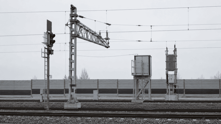 Kritische Bahninfrastruktur mit Signalmasten und Hochspannungsleitungen — Objekte verdeckter Auskundschaftung durch Low-Level-Agenten nach § 99 StGB.
