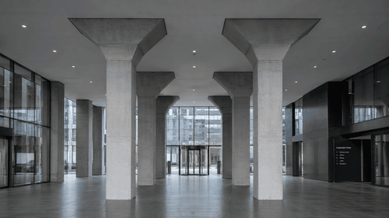 Eingangshalle eines Corporate Tower mit tragenden Betonstützen — Symbol für Organhaftung und § 346 UmwG