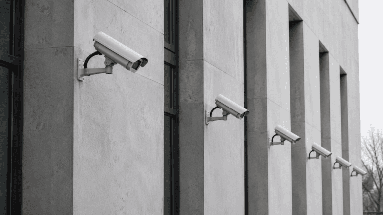 Reihe von Überwachungskameras an Sichtbetonwand — Sabotage im Strafrecht nach §§ 87, 88, 316b StGB.