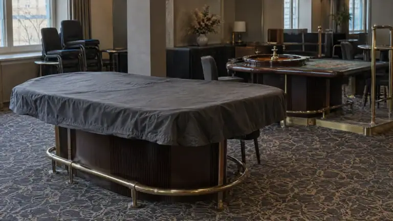 Abgedeckter Roulettetisch in einem leeren Spielsaal vor der Öffnung (Symbolbild, KI-generiert)